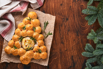 Bread buns Christmas tree with Roasted camembert cheese and rosemary on rustic background. Holiday recipes. Christmas menu. Christmas or Xmas pastries. Top view. Copy Space.