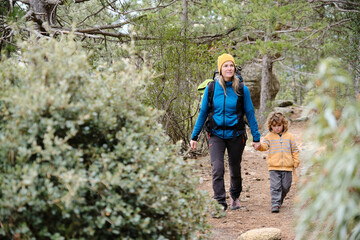 Naklejka na ściany i meble Mother hiker with her young son in the forest