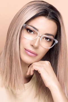 Women eyewear. Beautiful young woman in fashionable clear glasses posing in studio. Fashion eyewear and clear vision concept. Vertical format