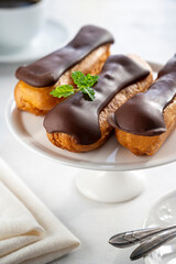 Eclairs with chocolate on white background. Delicious french sweet dessert