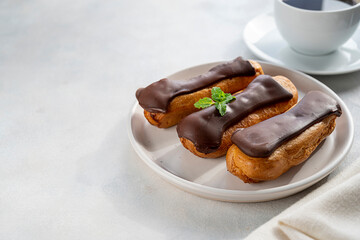 Eclairs with chocolate on white background. Delicious french sweet dessert, copy space