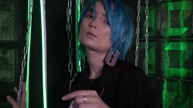 Portrait of an attractive LGBT model. A young man with blue hair with a chain