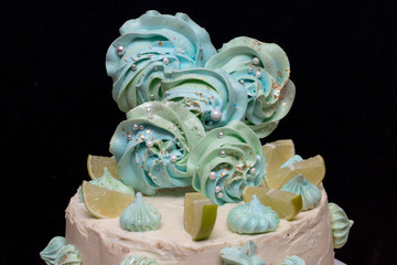 Close-up of blue and green meringues decorating the cake.