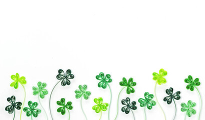 Quilling clover leaves for St. Patrick's Day banner. Green shamrock leaves made from rolled paper isolated on white background. Background for St. Patrick's Day with shamrock and trefoil.