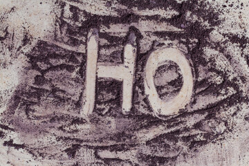 HO inscription drawn by purple color powder paint on a neutral background
