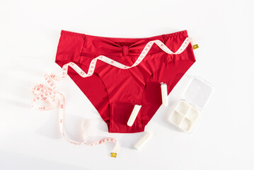 Women's underwear, tampons and metric measuring tape. Concept of premenstrual syndrome, critical...