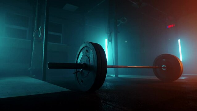 barbell on floor in dark sports hall for training of bodybuilder and powerlifter