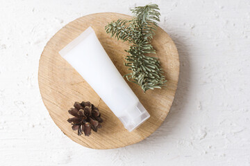 Eco cosmetic products for skin care of the face, body in white tube on a wooden podium next to a...