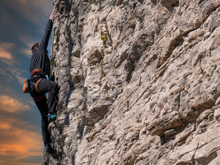 Climber on a rock in sunset hours