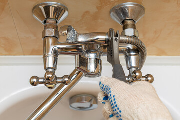 adjustable wrench tightens the nut connecting the hose and the water tap