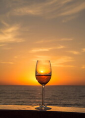 Glass of champagne against the background of the sea and sunrise
