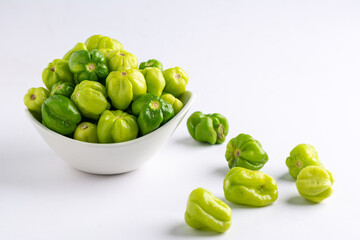 Fresh green peppers in a white ceramic bowl