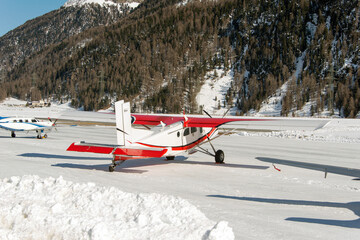 Private jets and a flying helicopter at Engadine St moritz airport