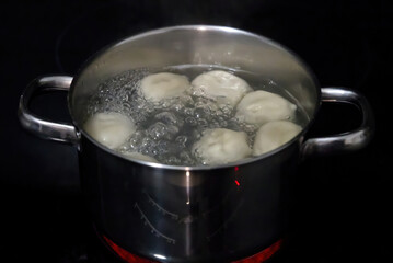 cooking the khinkals in boiling water. Boiled khinkali in a pan. the cook mixes the dumplings with a spoon in a pot. close up