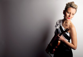 Fototapeta na wymiar Feeling the heart and soul of music. Studio shot of a beautiful young woman holding a violin.