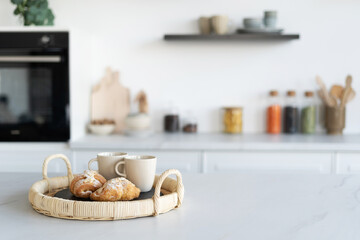 Obraz na płótnie Canvas Homemade croissants and cups in modern kitchen