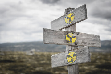 Radioactive logo on wooden vintage signpost outdoors in nature. Ukraine and russia conflict concept. - 489759292