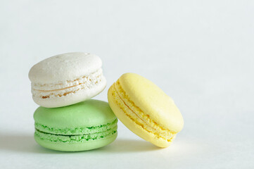 Fototapeta na wymiar 3 pieces of macaroons of different colors on a white background. Close-up, side view