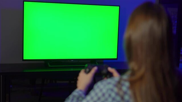 A young woman is playing a game console. Girl gamer and computer video games.