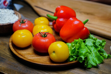 lettuce, yellow and red tomatoes and bell pepper with water drops. cucumbers.