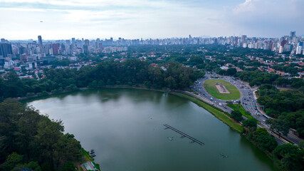 Fototapeta na wymiar Aerial view of Ibirapuera Park in São Paulo, Brazil. Park with preserved green area. Residential and commercial buildings in the background