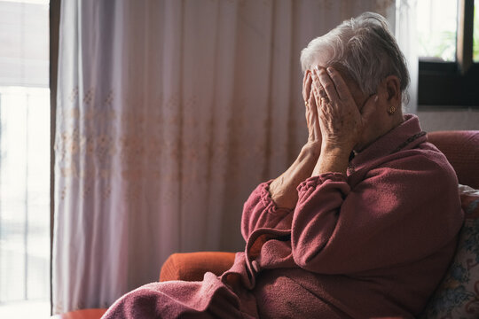 unrecognizable octogenarian old woman crying with her hands covering her face.concept of loneliness in old age and dependence.