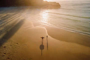 Foto auf Acrylglas Warm sunrise on ocean with shadow by surfers and waves. Joaquina beach in Brazil © artifirsov