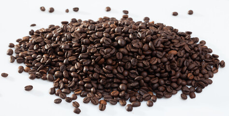 Pile of aromatic roasted coffee beans on white surface..