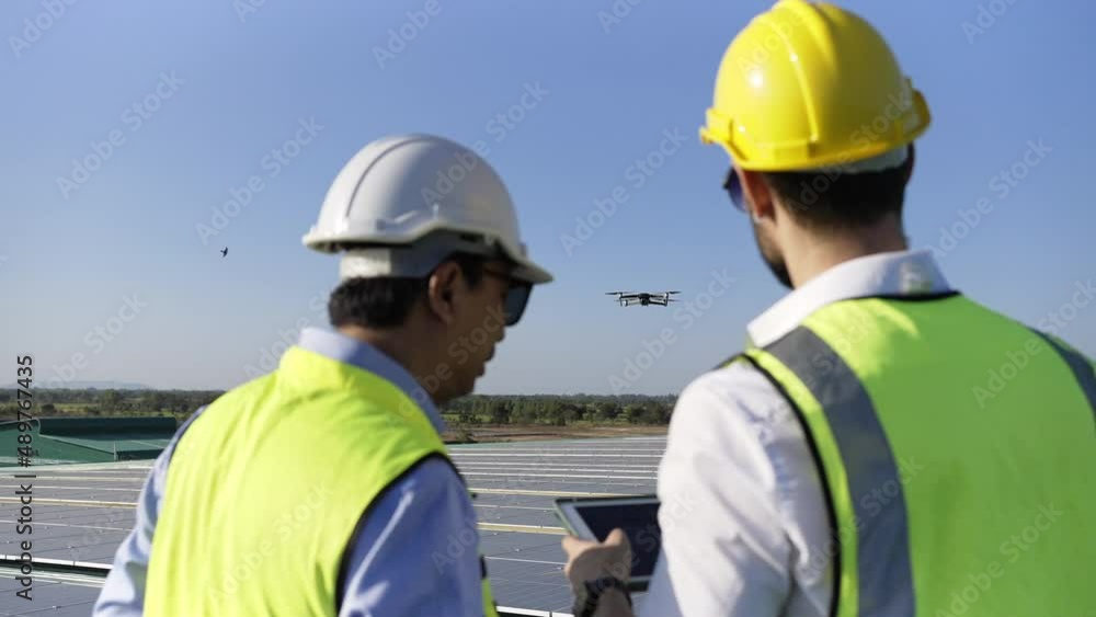 Wall mural professional engineer using drone and digital tablet maintaining solar cell panels together on build