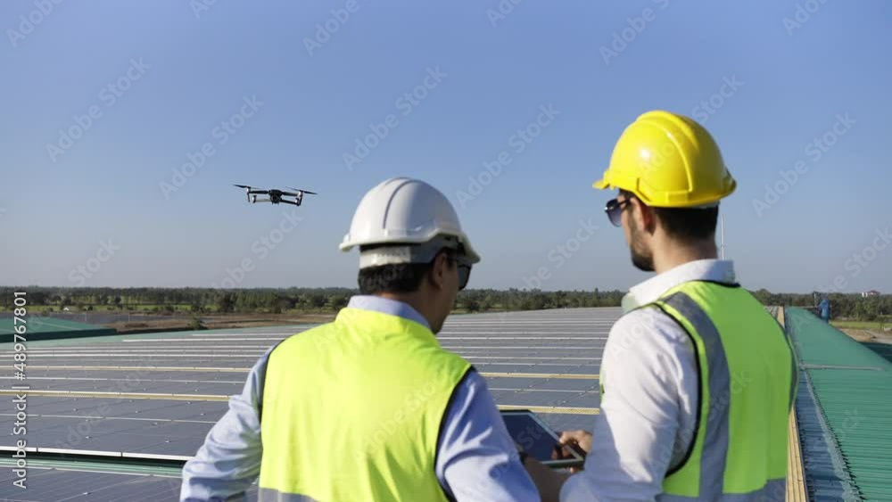 Wall mural professional engineer using drone and digital tablet maintaining solar cell panels together on build