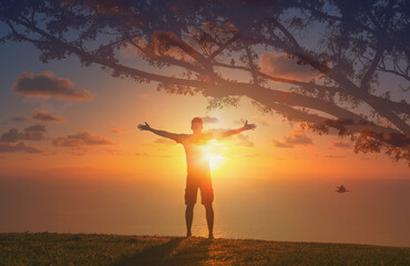 Man lifting his arms out up to the warm rays of sunshine, feeling feelings of happiness, hope and freedom 