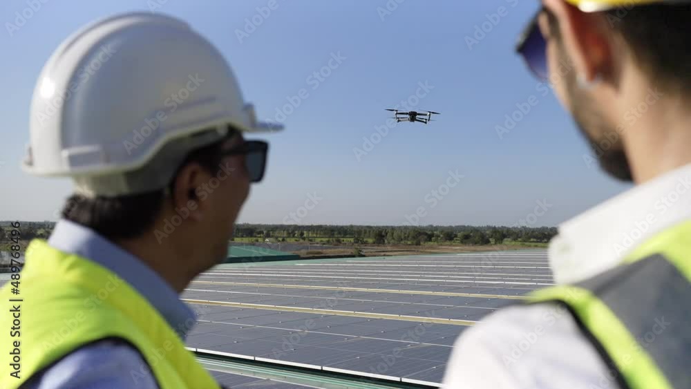 Wall mural professional engineer using drone and digital tablet maintaining solar cell panels together on build