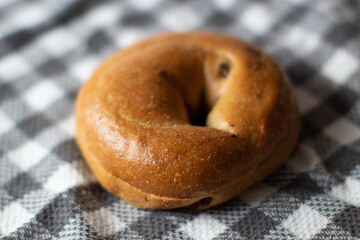 Cinnamon Raisin Bagel on plaid tablecloth