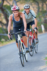 This couple enjoys competition. Shot of a couple focused on their bicycle ride together.