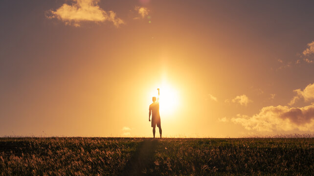 Young man outdoors with fist in the air feeling strong and confident. Victory and success concept
