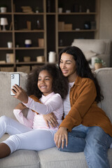 Vertical image smiling adorable African American kid girl streaming online storis in social...