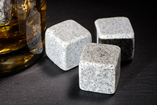 stones for chilling whiskey on a black background. A glass of whiskey in a glass.