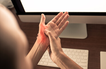 Woman suffering from carpal tunnel syndrome symptoms working on computer 