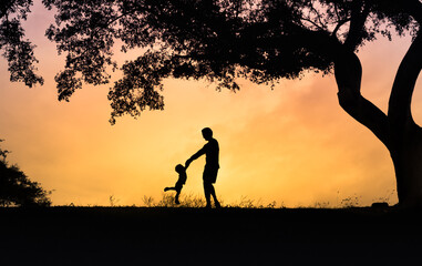 Happy father playing with his son holding him up in the air. Father son relationship concept.	