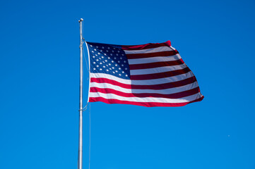 american flag in the wind on blue background