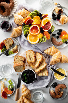 Brunch with fruit, croissants, donuts, jam and butter
