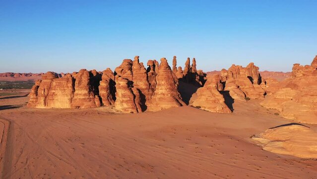 Aerial view of red sandstone peaks in Mada'in Salih, Saudi Arabia - rising, drone shot