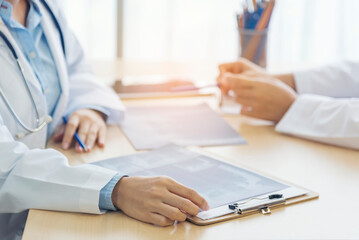 Close up hands of two women doctor medical lab discussing together healthcare teamwork. Two asian women hand doctors meeting write prescription medical clinic. Doctor discuss using laptop write note