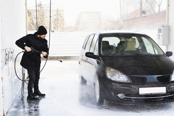  Car cleaning service. The man washing his car on self-service car. Express Car Wash