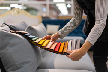 The woman chooses the fabric on the sofa. A young women looks at tissue samples. Selects the color...