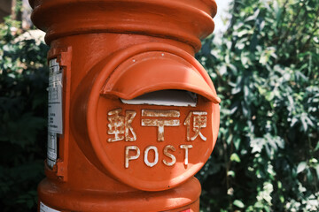 lose up old style postbox painted in red. Japanese characters (kanji) in post box is means - post...