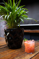 Margarita de fresa junto a maceta negra 