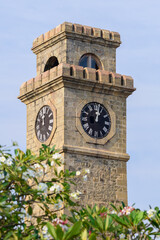 The Galle Clock tower close-up shot in Galle fort, rise above the trees, a beautiful tourist...