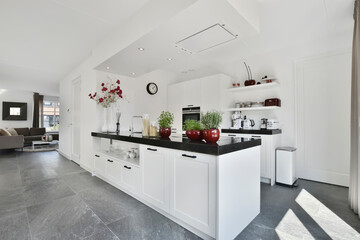 Silver hood in a minimal white kitchen interior with a comfortable wooden countertop. real photo