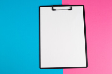 A notepad with a blank sheet of paper and a pen next to it on the table.